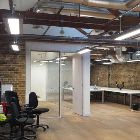 Converted industrial space with glass partitions and exposed services