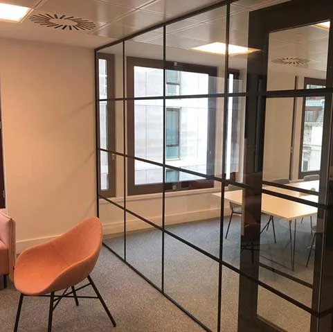 Black-framed glass partitions creating a meeting room